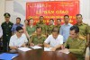 Ông Võ Đình Kha (người mặc áo trắng ngồi bên phải) - Phó Giám đốc Sở Ngoại vụ tỉnh Bình Định và ông Somxay Keophasak (người mặc quân phục Lào ngồi bên trái) đại diện bên nhận tỉnh Salavan