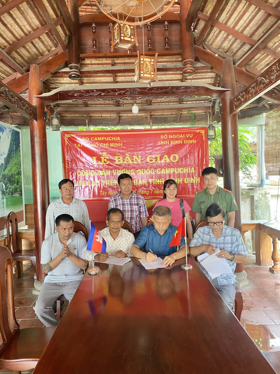 Ông Võ Đình Kha (người mặc áo xanh đậm ngồi bên phải) - Phó Giám đốc Sở Ngoại vụ tỉnh Bình Định và ông Keo Bunrith (người ngồi bên trái) - Tổng lãnh sự quán Vương quốc Campuchia tại TP Hồ Chí Minh ký biên bản bàn giao